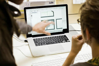 Zwei Menschen vor einem Computer